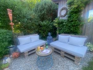 a garden with two blue couches and a table at Tiny House 47 in Egloffstein