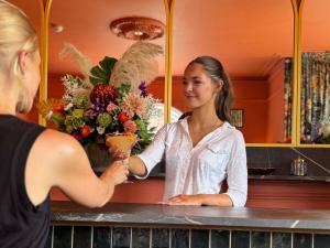 Eine Frau steht mit einem Kunden an einem Tresen. in der Unterkunft The Emsworth Hotel in Emsworth