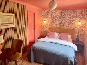 ein Schlafzimmer mit einem Bett mit floraler Tapete in der Unterkunft The Emsworth Hotel in Emsworth