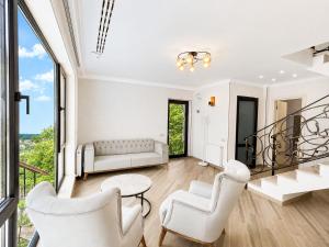 a living room with white furniture and large windows at Crown Villa Bakuriani in Bakuriani