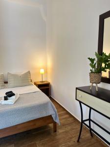 a bedroom with a bed and a dresser with a mirror at Apocalypsis Houses in Skala