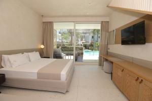 a hotel room with a bed and a view of a pool at Elite Bay Hotel Lalez Durres in Lalëz