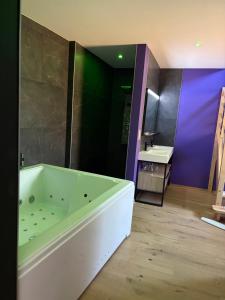 ein Badezimmer mit Badewanne und Waschbecken in der Unterkunft Love room l'Evasion in Esprels