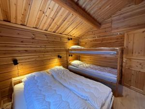 a room with two beds in a wooden cabin at Charmig timmerstuga i Vemdalen in Vemhån