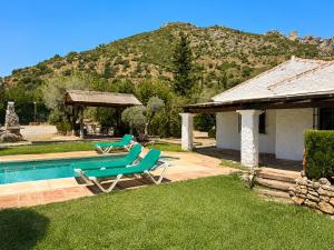 a pool with two lounge chairs and a house at Villa La Clavelina Rocabella in El Chorro
