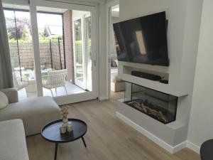 a living room with a fireplace with a flat screen tv at Huize Zondag in Beneden-Leeuwen