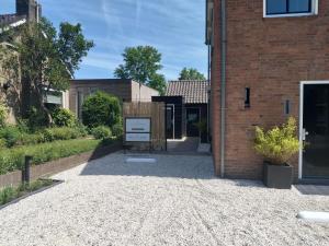 a brick building with a sign in front of it at Huize Zondag in Beneden-Leeuwen