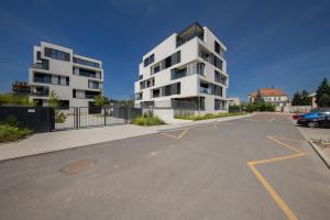 a parking lot with a white apartment building at Island Safehouse in Olomouc