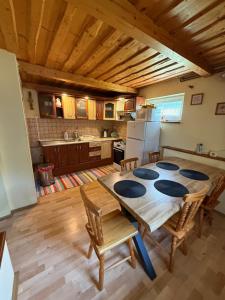 a kitchen with a large wooden table and chairs at Chatka Hanka in Terchová +12 photos
