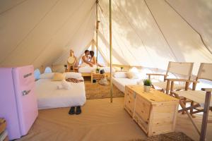 two people in a tent with two beds at Kampaoh Palamós Internacional in Palamós