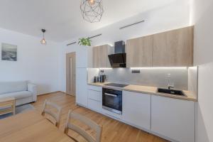a kitchen with white cabinets and a table and chairs at Island Safehouse in Olomouc