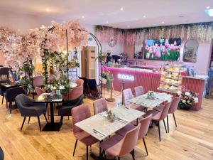 ein Restaurant mit Tischen und Stühlen und rosa Blumen in der Unterkunft The Emsworth Hotel in Emsworth + 47 Fotos