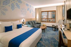 a hotel room with a large bed and a living room at Jiwar Al Madina Hotel in Medina +71 photos
