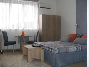 a bedroom with two beds and a table and a chair at Valor Central Apartments in Skopje