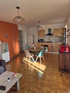 a living room with a table and chairs and a kitchen at La Verdière in Barjols