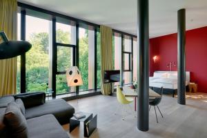 a living room with a couch and a bedroom at Studios & Spa Suites Rigiblick in Zurich