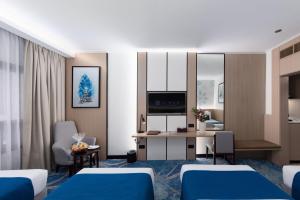 a hotel room with two beds and a desk at Jiwar Al Madina Hotel in Medina