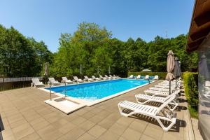 a pool with chaise lounge chairs and a bunch ofituresitures at Kalabash Apartments in Sovata