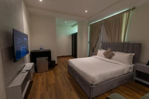 a bedroom with a bed and a flat screen tv at The Address Boutique Hotel Karachi in Karachi