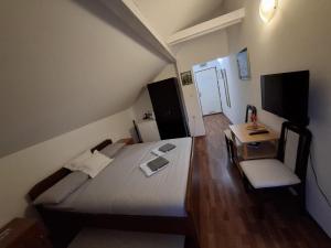 a bedroom with a bed and a table and a chair at Vila Milka in Lepterija