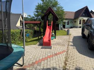 a playground in a yard with a red slide at Chatka Hanka in Terchová
