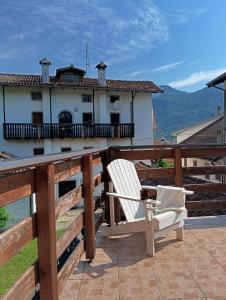 a white chair on a balcony with a house at Mountain Suite in Raveo