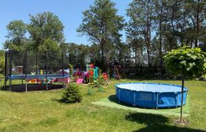 a yard with two play structures and a pool at Dom nad jeziorem Mazury pomost segment 2 in Giżycko
