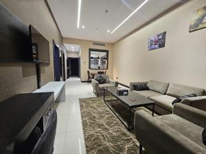a living room with a couch and a table at Basra Platinum Hotel in Al Başrah