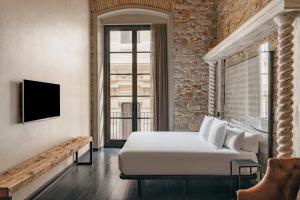 a hotel room with a bed and a tv at Aparthotel Arai 4* Superior in Barcelona