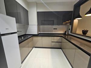 a kitchen with white cabinets and a white refrigerator at Basra Platinum Hotel in Al Başrah +25 photos