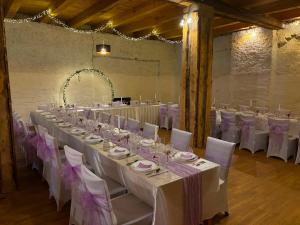 a long table with white tables and chairs in a room at Bohemica Apartman 4 in Kouřim +58 photos