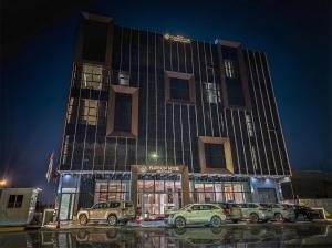 a building with cars parked in front of it at Basra Platinum Hotel in Al Başrah