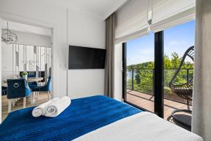 a bedroom with a blue and white bed and a balcony at Lake Rental Spacerowa in Mikołajki