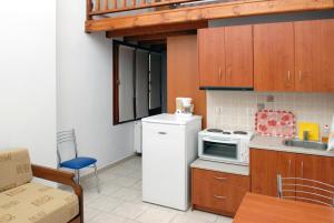 a kitchen with a white refrigerator and a microwave at Zouzoula House in Milina