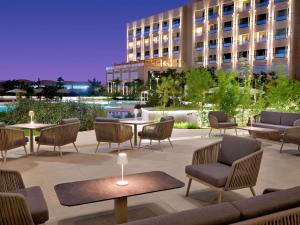 a patio with tables and chairs and a building at Mövenpick Hotel Waad Al Shamal in Ţurayf