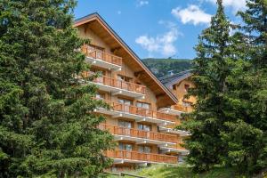 a resort building with trees in front of it at Résidence Le Golf in Méribel