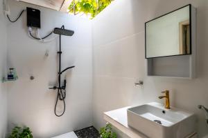 a white bathroom with a sink and a mirror at Villa Argento in Rimbudu