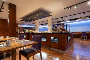 ein Restaurant mit einem Tisch und einer Theke mit Essen in der Unterkunft Exe Moncloa in Madrid