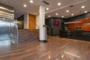 eine leere Lobby mit Treppenhaus und gläsernem Aufzug in der Unterkunft Exe Moncloa in Madrid