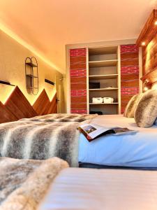 a bedroom with two beds and a book at Hôtel Ski Lodge - Chambres & Appartements - Village Montana in Val-d'Isère