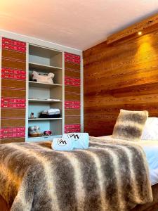 a bedroom with a bed with a wooden wall at Hôtel Ski Lodge - Chambres & Appartements - Village Montana in Val-d'Isère