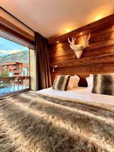 a bedroom with a large bed with a large window at Hôtel Ski Lodge - Chambres & Appartements - Village Montana in Val-d'Isère