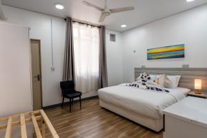 a bedroom with a bed and a desk and a chair at Villa Argento in Rimbudu