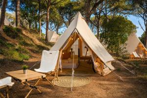 a tent with two chairs and a table and a table sidx sidx at Kampaoh Calella de Palafrugell in Calella de Palafrugell