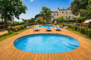 a large pool with lounge chairs and a man standing next to it at Kampaoh Calella de Palafrugell in Calella de Palafrugell