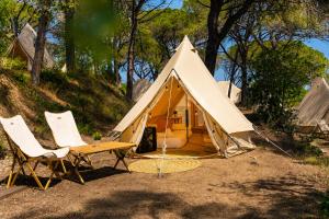 a tent with two chairs and a table in front at Kampaoh Calella de Palafrugell in Calella de Palafrugell