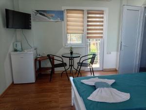 a bedroom with a bed and a table and chairs at Guest House Guriani in Grigoleti