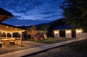 a backyard with a slide and a playground at night at Cerdacul cu Amintiri in Câmpulung Moldovenesc