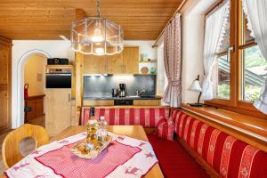 a living room with a table and a kitchen at Weibhauser Franzl in Ruhpolding