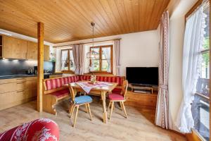 a living room with a table and a kitchen at Weibhauser Franzl in Ruhpolding
